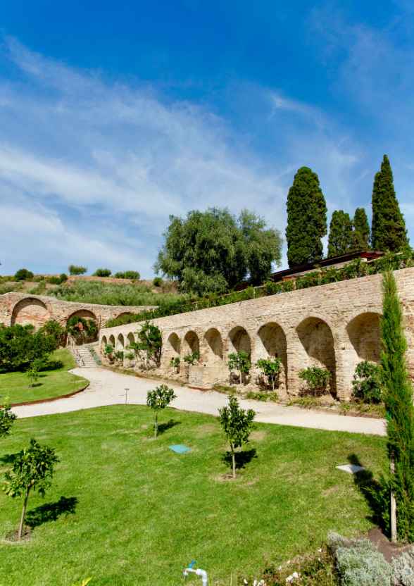 Porticato a nicchie storiche e camminamenti del giardino botanico Hortus.